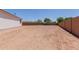 Dirt backyard with privacy wall, awaiting landscaping at 40595 W Michaels Dr, Maricopa, AZ 85138
