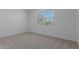 Bright bedroom featuring neutral carpet, large window and white walls at 40595 W Michaels Dr, Maricopa, AZ 85138