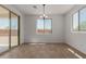 Bright dining room with large windows, chandelier, and sliding glass doors to the backyard at 40595 W Michaels Dr, Maricopa, AZ 85138