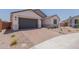 Single-story home with paver driveway, desert landscaping, and a two-car garage at 40595 W Michaels Dr, Maricopa, AZ 85138