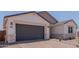 Close up of a 2 car garage with stone accents on a stucco home with brick paver driveway at 40595 W Michaels Dr, Maricopa, AZ 85138