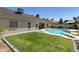 Expansive backyard with a refreshing pool, green lawn, and mature landscaping, ideal for outdoor activities at 4137 W Cielo Grande --, Glendale, AZ 85310