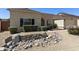 Attractive home exterior featuring desert landscaping with decorative stone and mature bushes at 4137 W Cielo Grande --, Glendale, AZ 85310
