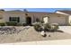 Charming single-story home showcasing desert landscaping, gravel yard, mature plants and covered entryway at 4137 W Cielo Grande --, Glendale, AZ 85310