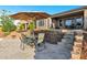 Backyard features a patio area with table and chairs, artificial turf, and a retaining wall at 41584 W Springtime Rd, Maricopa, AZ 85138