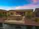 Scenic backyard featuring a cozy patio, manicured lawn, and tranquil lakefront views at 41584 W Springtime Rd, Maricopa, AZ 85138
