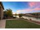Inviting backyard with lush lawn, beautiful landscaping, and serene waterfront views at 41584 W Springtime Rd, Maricopa, AZ 85138