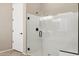 Modern bathroom featuring a glass-enclosed shower with bronze hardware and white door at 41584 W Springtime Rd, Maricopa, AZ 85138