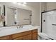 Traditional bathroom with wood vanity and walk-in shower with bronze hardware at 41584 W Springtime Rd, Maricopa, AZ 85138