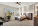 Bedroom featuring a ceiling fan, large format windows, carpeted floors, and natural lighting at 41584 W Springtime Rd, Maricopa, AZ 85138