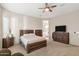 Bedroom with large format windows, a ceiling fan, natural lighting, carpeted floors and traditional furniture at 41584 W Springtime Rd, Maricopa, AZ 85138