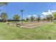 Outdoor bocce ball court with manicured lawn, benches, and lights for evening play at 41584 W Springtime Rd, Maricopa, AZ 85138