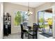 Cozy dining area with lake views, modern light fixtures, a glass table, stylish seating, and a sleek wine rack at 41584 W Springtime Rd, Maricopa, AZ 85138