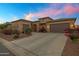 Charming, Southwestern-style home with a well-manicured lawn and a three-car garage at 41584 W Springtime Rd, Maricopa, AZ 85138