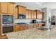 Kitchen featuring granite countertops, a stainless steel sink, an over-the-range microwave and a built-in oven and cooktop at 41584 W Springtime Rd, Maricopa, AZ 85138