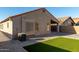 This home features a well-maintained backyard with synthetic grass and a covered parking area at 42067 W Anne Ln, Maricopa, AZ 85138