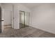 Neutral bedroom with plush carpet, mirrored closet, and bright window offers a serene living space at 42067 W Anne Ln, Maricopa, AZ 85138