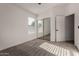 Bright bedroom with carpeted floors, sunlit window, and a mirrored sliding closet offers comfort and style at 42067 W Anne Ln, Maricopa, AZ 85138