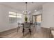 Contemporary dining area with a modern chandelier, sleek table, and access to the patio at 42067 W Anne Ln, Maricopa, AZ 85138