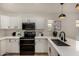 Well-equipped kitchen with stainless steel appliances, white cabinetry, and quartz countertops at 42067 W Anne Ln, Maricopa, AZ 85138