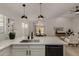 Modern kitchen with sleek countertops, stainless steel appliances, and an open layout to the living room at 42067 W Anne Ln, Maricopa, AZ 85138