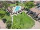 An aerial view of a community pool surrounded by townhomes, trees, and green grass at 4601 N 102Nd Ave # 1116, Phoenix, AZ 85037