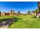 View of community landscaping, well-maintained grass and desert landscaping with multiple brown buildings and blue sky above at 4601 N 102Nd Ave # 1116, Phoenix, AZ 85037