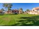 A community greenspace featuring mature trees, manicured landscaping and classic townhomes at 4601 N 102Nd Ave # 1116, Phoenix, AZ 85037