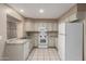 Well-lit kitchen features white appliances, granite countertops, and tile flooring at 4601 N 102Nd Ave # 1116, Phoenix, AZ 85037
