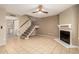 Spacious living room featuring neutral tile floors, a cozy fireplace, and a staircase, perfect for relaxing at 4601 N 102Nd Ave # 1116, Phoenix, AZ 85037