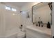 Bright bathroom features a tub/shower combo, white subway tiles, and modern black fixtures for a clean design at 4855 E Gary St, Mesa, AZ 85205