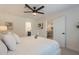 Bright bedroom features a ceiling fan, white walls, and a view to the ensuite bathroom and dining area at 4855 E Gary St, Mesa, AZ 85205