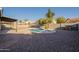 Private backyard pool surrounded by gravel landscaping and shaded by mature palm trees, perfect for relaxation at 4855 E Gary St, Mesa, AZ 85205