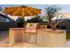 Outdoor kitchen with stainless steel grill and tiled countertops under umbrella with lights at sunset at 4960 E Dale Ln, Cave Creek, AZ 85331