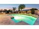 Backyard pool with waterfall feature, stone accents, and desert landscaping at dusk at 4960 E Dale Ln, Cave Creek, AZ 85331