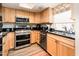 Well-lit kitchen with stainless steel appliances, light wood cabinets, and dark countertops at 5209 N 78Th St, Scottsdale, AZ 85250