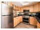 Kitchen featuring stainless steel appliances, light wood cabinets, and stylish black countertops at 5209 N 78Th St, Scottsdale, AZ 85250