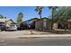 Modest single-story home with mature trees, a covered carport, and off-street parking in front of the house at 604 W Emelita Ave, Mesa, AZ 85210