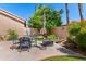Outdoor dining set sits on backyard patio surrounded by garden flowers and lush plants at 67 W Sarah Ln, Tempe, AZ 85284