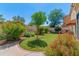 Landscaped backyard offers a charming space with lush greenery and vibrant red flowers at 67 W Sarah Ln, Tempe, AZ 85284