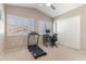 Bedroom features a large window with shutters, a treadmill, and a desk with a computer at 67 W Sarah Ln, Tempe, AZ 85284