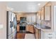 Well-lit kitchen featuring stainless steel appliances, wood cabinets, and dark countertops at 67 W Sarah Ln, Tempe, AZ 85284