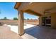 Covered back patio with ceiling fan overlooks the backyard featuring a pool, gravel, and block fence at 6944 S Morning Dew Ln, Buckeye, AZ 85326