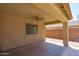 Covered back patio with ceiling fan and window overlooking the backyard and block fence at 6944 S Morning Dew Ln, Buckeye, AZ 85326