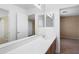 Bathroom with a long vanity, sink, and a mirror reflecting the adjacent rooms at 6944 S Morning Dew Ln, Buckeye, AZ 85326