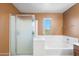 Bright bathroom featuring a bathtub, shower, and a window offering natural light at 6944 S Morning Dew Ln, Buckeye, AZ 85326