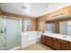 Bathroom with tile flooring, dual sink vanity, a shower with glass doors, and a large soaking tub at 6944 S Morning Dew Ln, Buckeye, AZ 85326