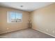 Bedroom with a window and carpeted floors, offering a cozy and comfortable space at 6944 S Morning Dew Ln, Buckeye, AZ 85326
