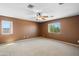 Large bedroom with carpet, a ceiling fan, and two windows offering natural light and outdoor views at 6944 S Morning Dew Ln, Buckeye, AZ 85326