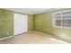 Bedroom featuring green walls, neutral tile flooring, a large closet with sliding doors, and a window at 6944 S Morning Dew Ln, Buckeye, AZ 85326